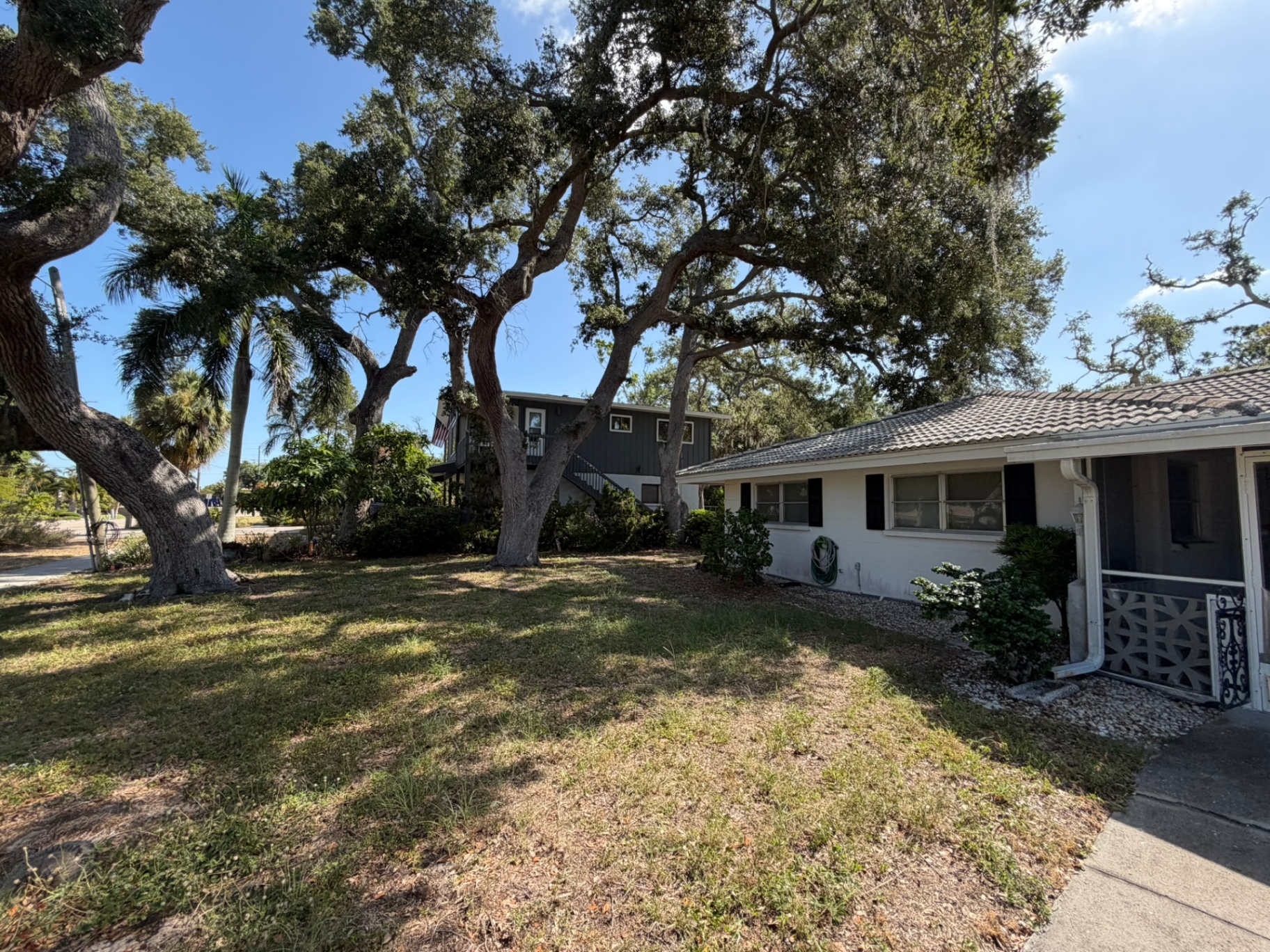 Front yard with mature oak trees โ Palma Sola off-market listing photo 3